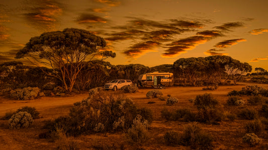 a couple of vehicles parked on a dirt road