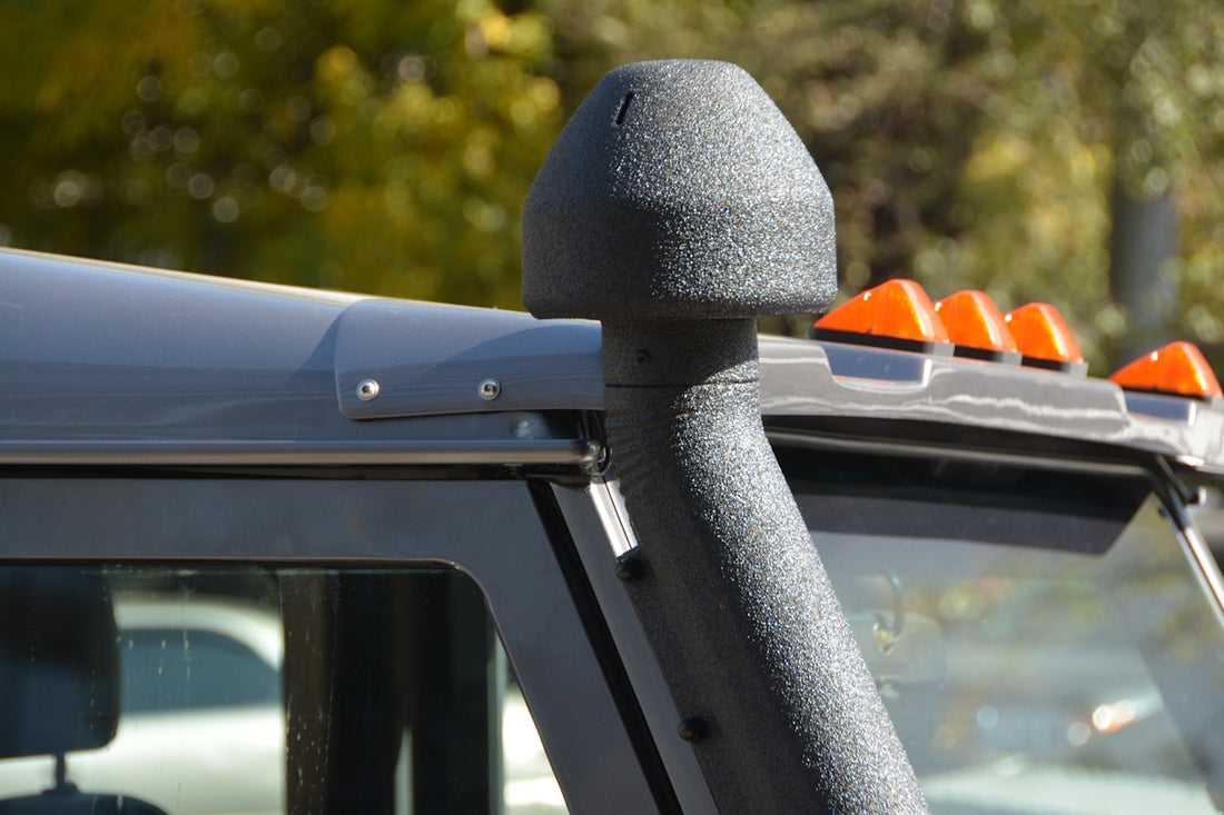 Snorkel and lights on a gray off-road vehicle.