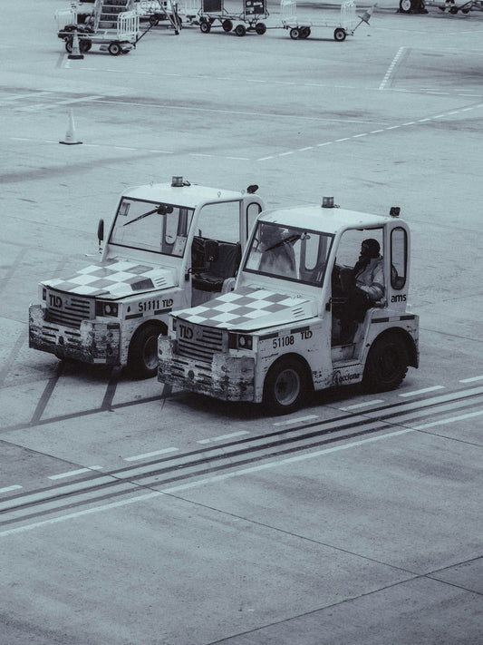 Two airport tugs parked on tarmac
